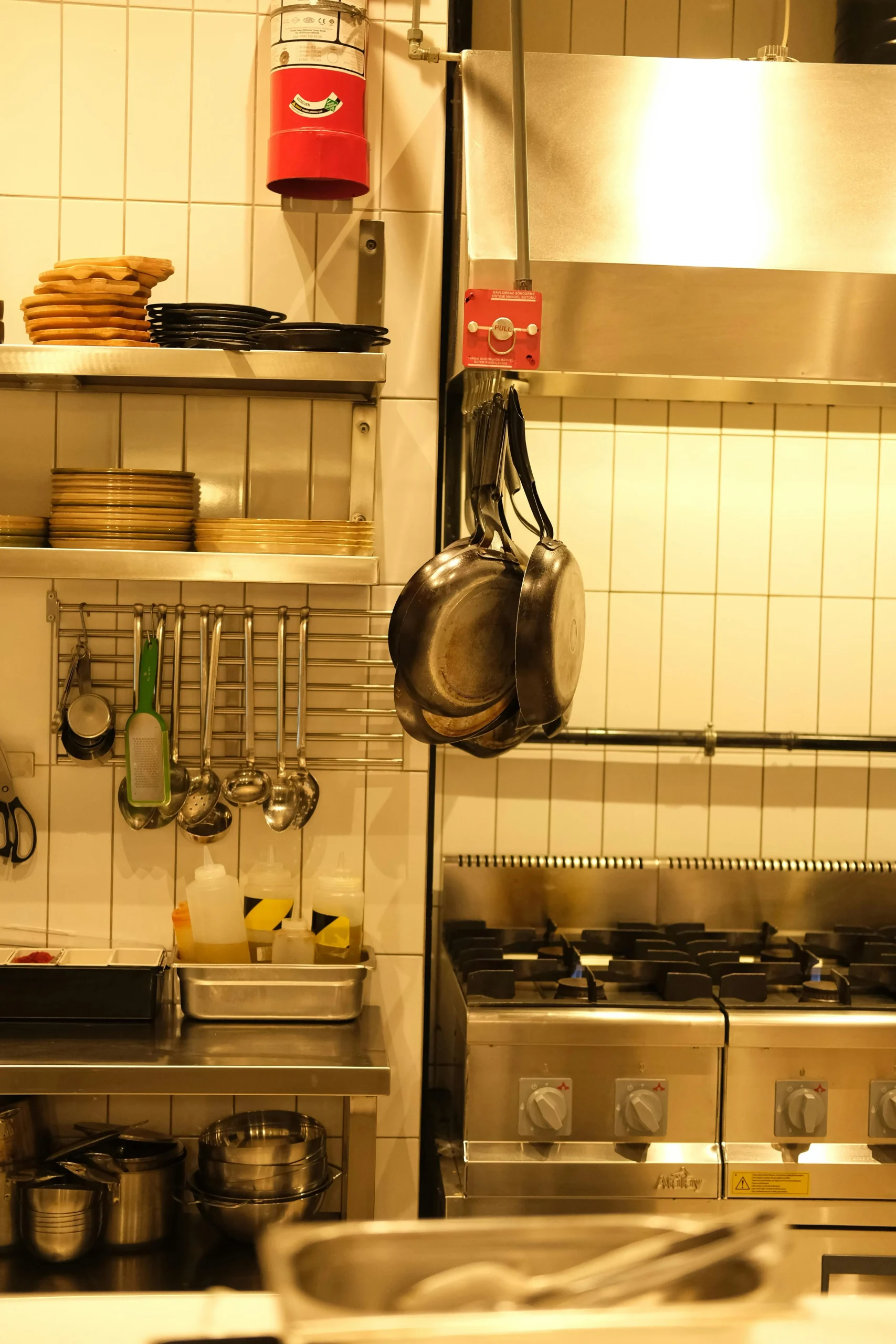 Imagen de una cocina, en primer plano unas sartenes colgando